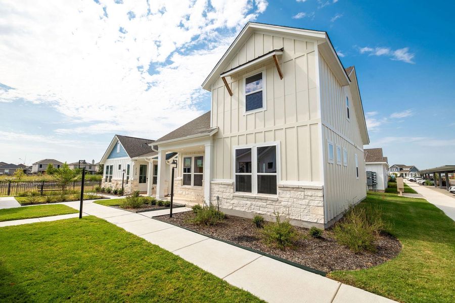 Board and batten siding pairs beautifully with stone accents along the manicured concrete walkway. Board and batten siding pairs beautifully with stone accents along the manicured concrete walkway.