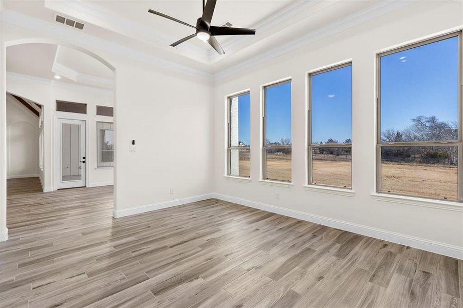 Playroom/Game room featuring ceiling fan, ornamental molding, a raised ceiling, custom flooring