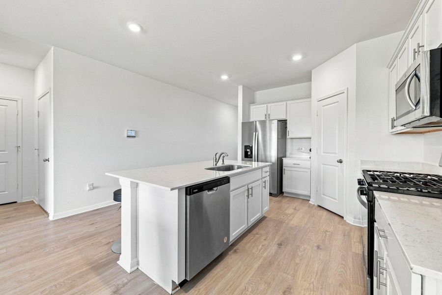 Gleaming stone countertops and warm wood floors define this open culinary space.