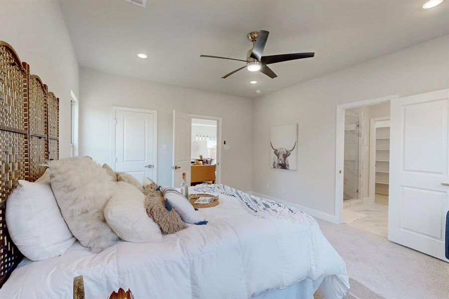 Main Carpeted bedroom featuring connected bathroom, a spacious closet, ceiling fan, and a closet