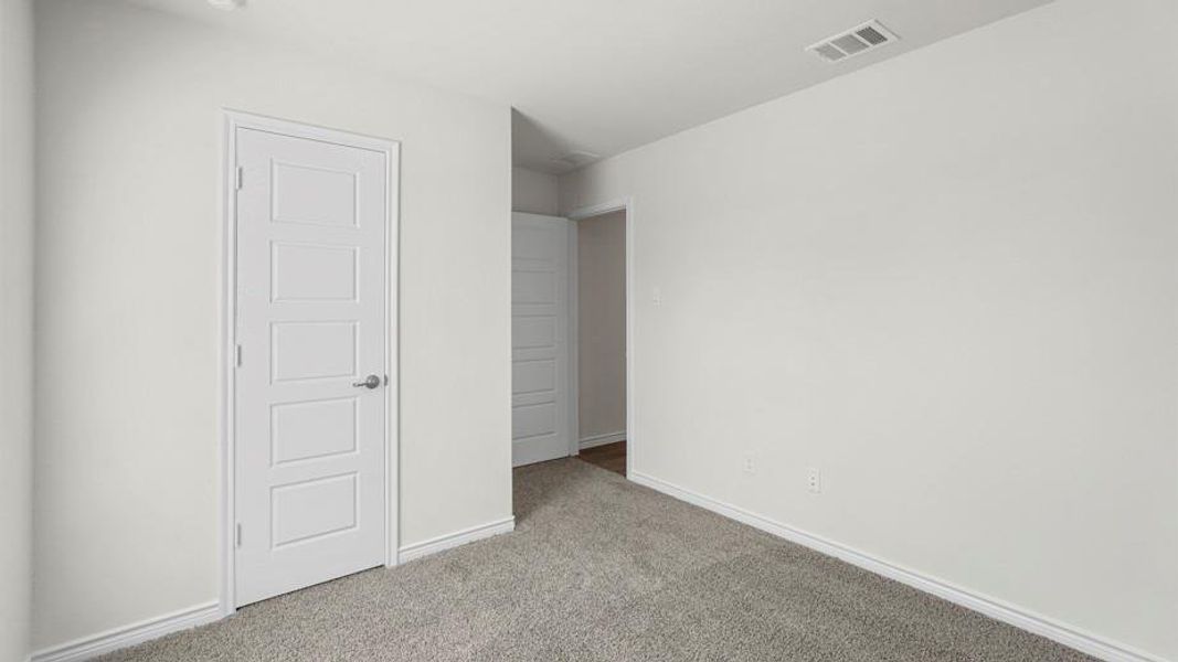 This space features neutral-toned carpeting and light-colored walls, providing a versatile foundation for personalization