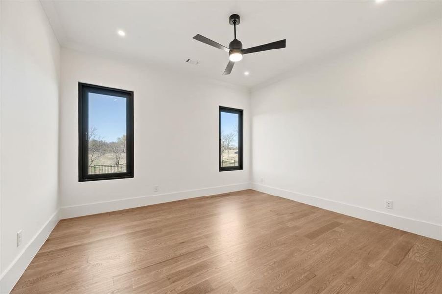 Spare room featuring light wood finished floors, ceiling fan, and recessed lighting