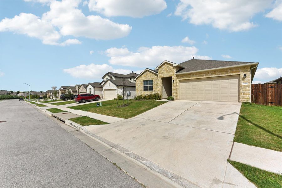 Ranch-style house featuring stone siding, a garage, concrete driveway, and a residential view Ranch-style house featuring stone siding, a garage, concrete driveway, and a residential view