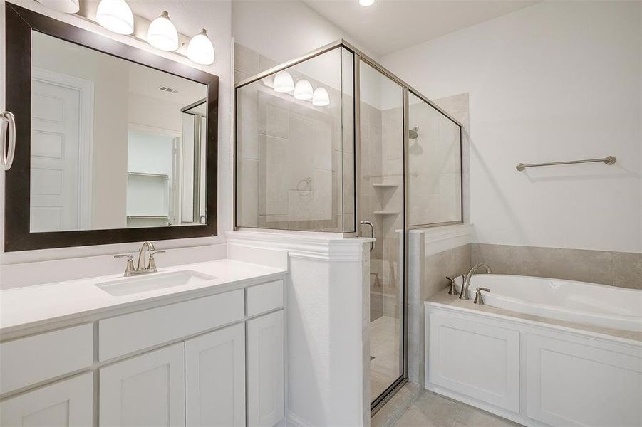 Bathroom with tile patterned flooring, independent shower and bath, and vanity