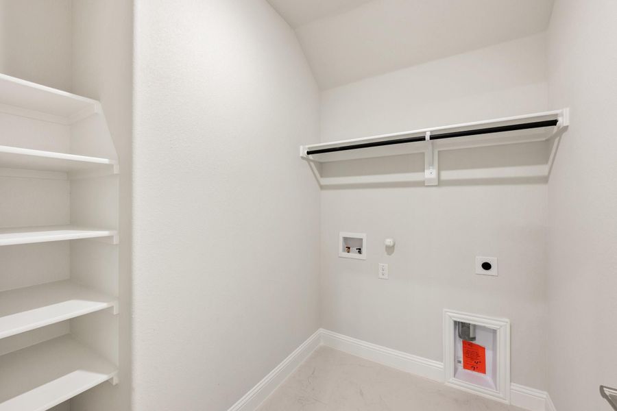 Laundry room with white walls, upper hanging rod, open shelving, and washer and dryer hookups Laundry room with white walls, upper hanging rod, open shelving, and washer and dryer hookups