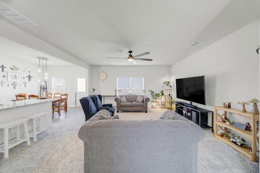 Living room with light colored carpet and ceiling fan
