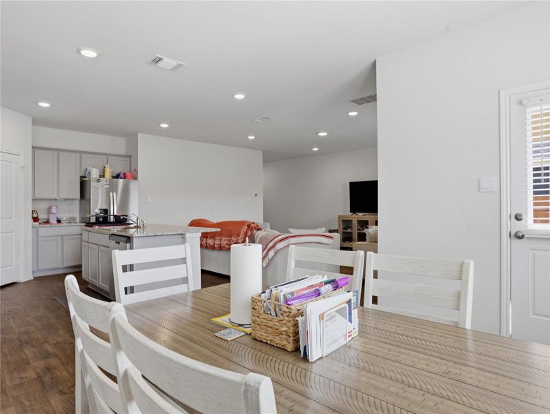 Recessed lighting illuminates this modern open-concept space featuring a dining area connected to the kitchen. Recessed lighting illuminates this modern open-concept space featuring a dining area connected to the kitchen.