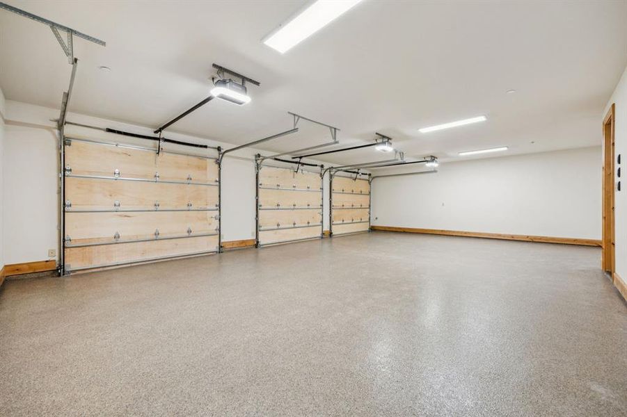Garage featuring baseboards and a garage door opener