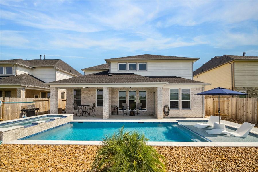 Inviting outdoor space showcasing a contemporary in-ground heated saltwater pool, comfortable seating, and a fenced yard. An ideal retreat for summer days and outdoor entertaining. Inviting outdoor space showcasing a contemporary in-ground heated saltwater pool, comfortable seating, and a fenced yard. An ideal retreat for summer days and outdoor entertaining.