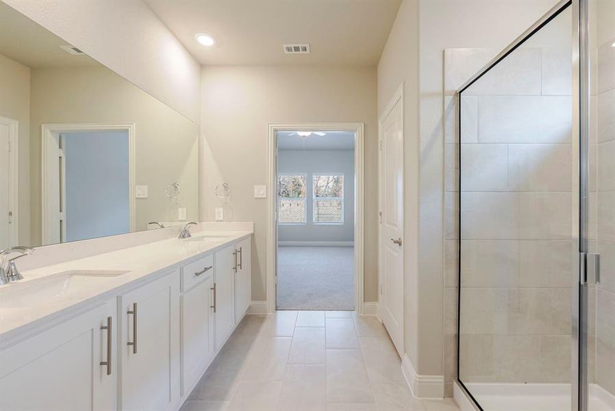 Full bathroom featuring double vanity, a shower stall, light tile patterned floors, and recessed lighting Full bathroom featuring double vanity, a shower stall, light tile patterned floors, and recessed lighting