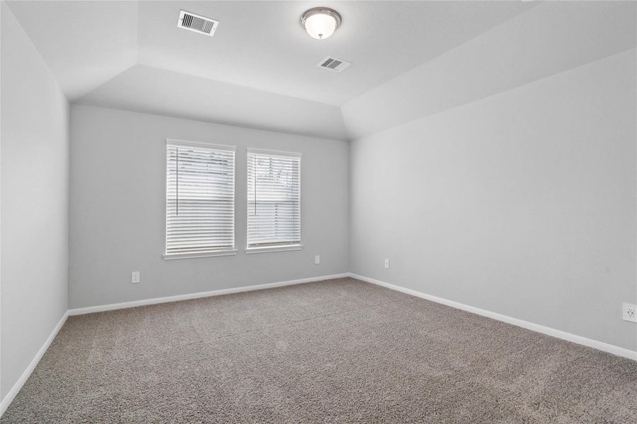 The primary bedroom provides a peaceful escape with a bright, neutral palette, sloped ceilings, large windows, and plush carpet flooring, creating a calm and restorative atmosphere to end your day. The primary bedroom provides a peaceful escape with a bright, neutral palette, sloped ceilings, large windows, and plush carpet flooring, creating a calm and restorative atmosphere to end your day.