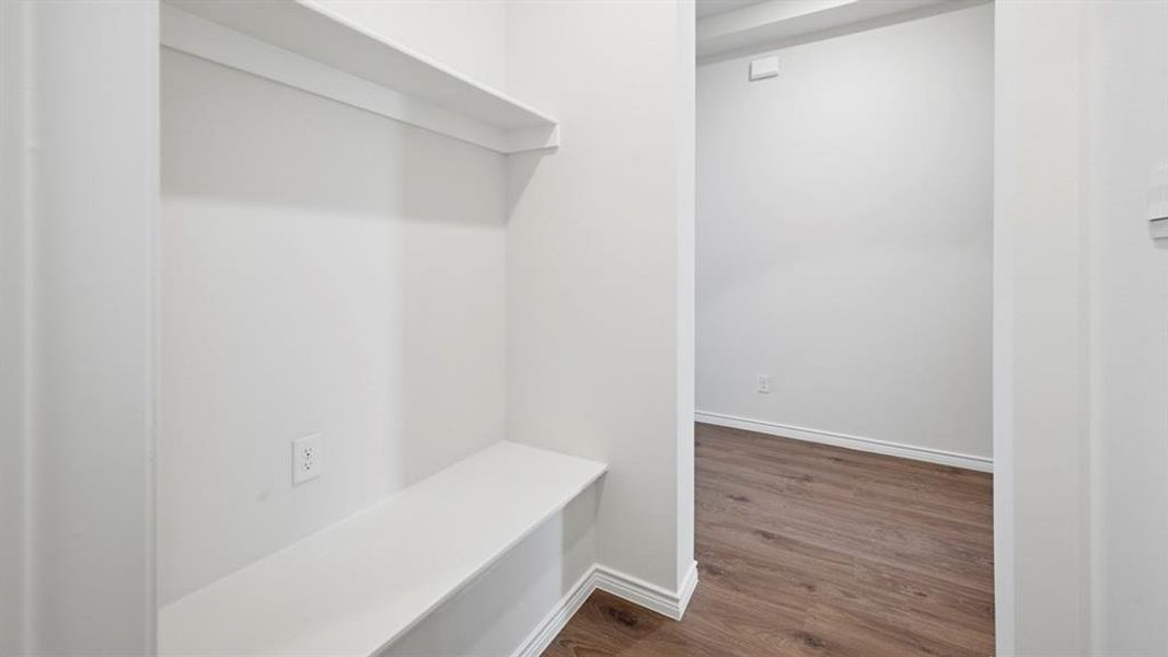 Mudroom featuring dark wood finished floors and baseboards