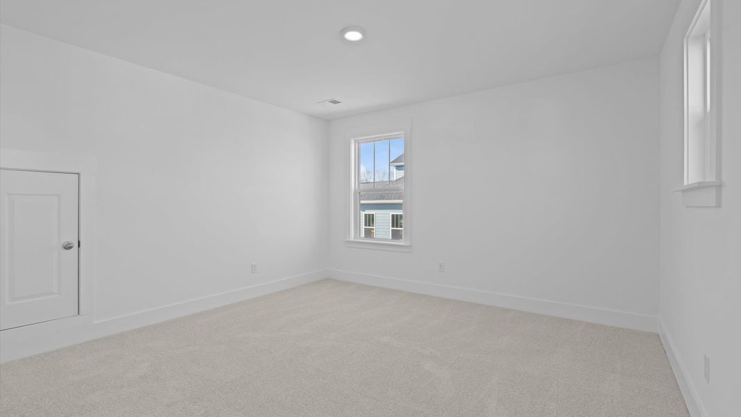 Superior comfort in this light-filled bedroom with plush carpeting and thoughtfully placed large windows