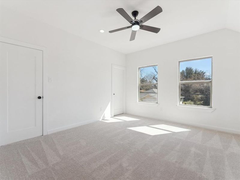 Spare room featuring light carpet, ceiling fan, baseboards, and recessed lighting