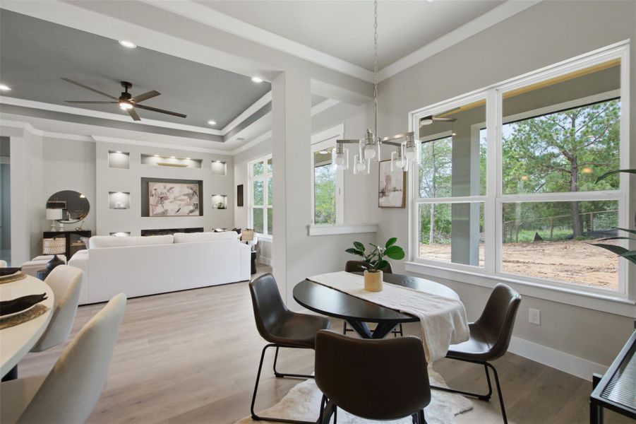 An open floorplan seamlessly connects dining and living areas, offering expansive views of the natural surroundings. An open floorplan seamlessly connects dining and living areas, offering expansive views of the natural surroundings.
