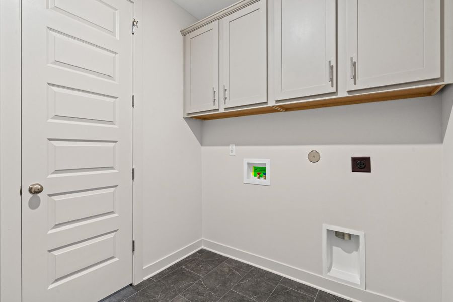 Laundry area featuring washer hookup, electric dryer hookup, and cabinet space