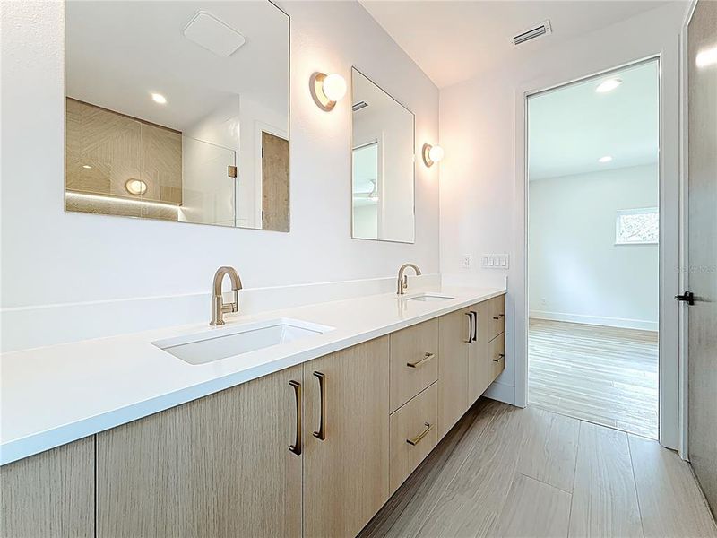 Spa-like en-suite bath featuring dual sinks, an oversized walk-in shower, and a private water closet. Spa-like en-suite bath featuring dual sinks, an oversized walk-in shower, and a private water closet.