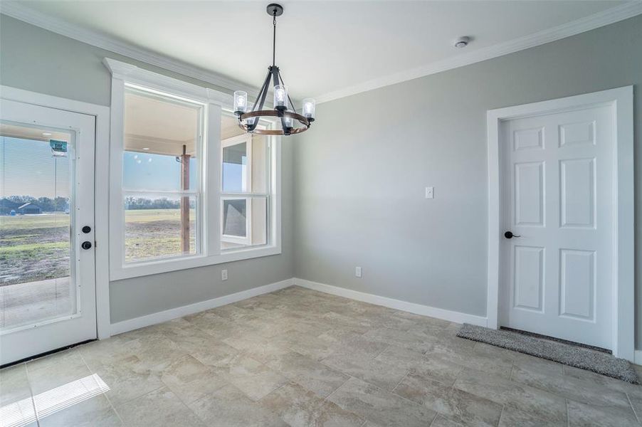 Unfurnished dining area featuring a chandelier and ornamental molding Unfurnished dining area featuring a chandelier and ornamental molding