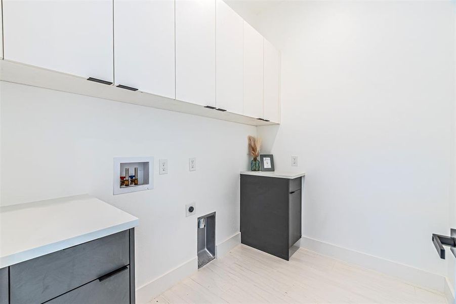 Washroom with washer hookup, electric dryer hookup, light wood-type flooring, and cabinet space Washroom with washer hookup, electric dryer hookup, light wood-type flooring, and cabinet space