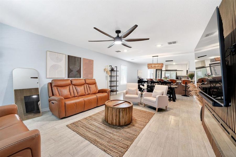 Open-concept living space featuring wood-finish flooring, recessed lighting, and a modern ceiling fan