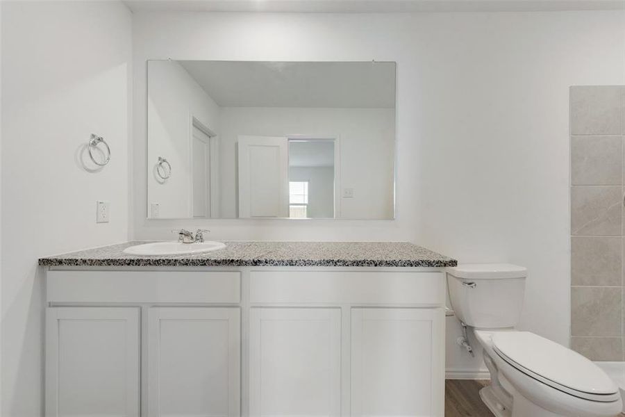 Bathroom featuring vanity, hardwood / wood-style floors, and toilet