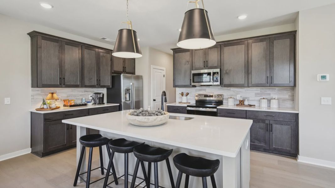 Kitchen with quartz countertops, pendant lighting, and hard-surface flooring