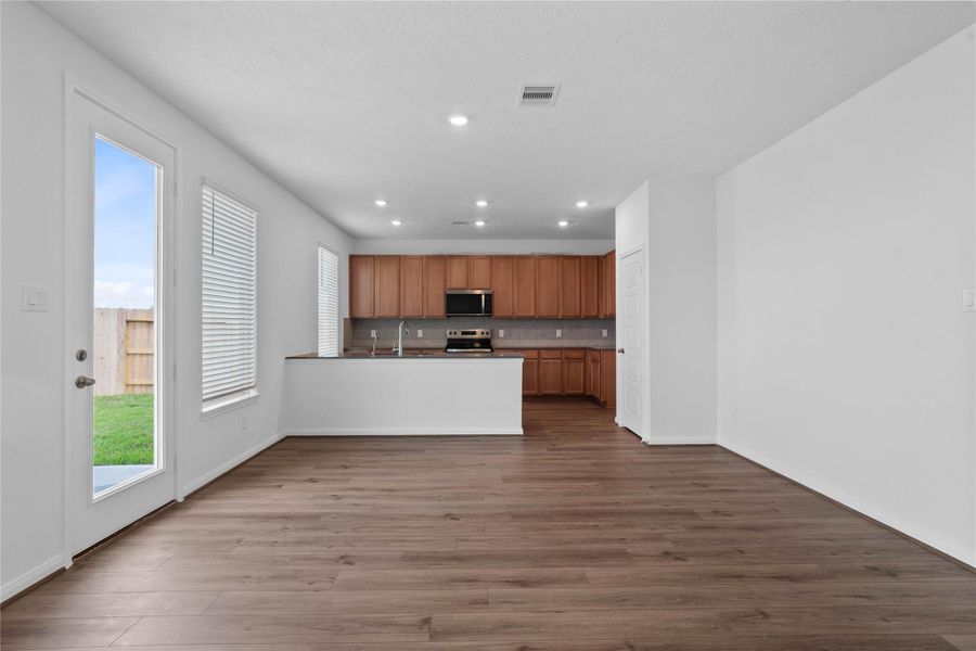 Create lasting memories around the table with family and friends in this inviting breakfast/dining space! It showcases high ceilings, large window with blinds, access door to the backyard, vinyl plank flooring, and recessed lighting for a warm and welcoming atmosphere.