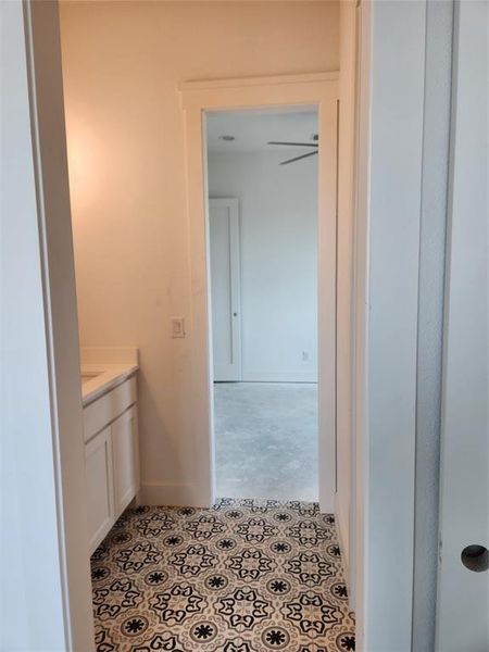 Bathroom featuring ceiling fan, vanity, and tile patterned flooring