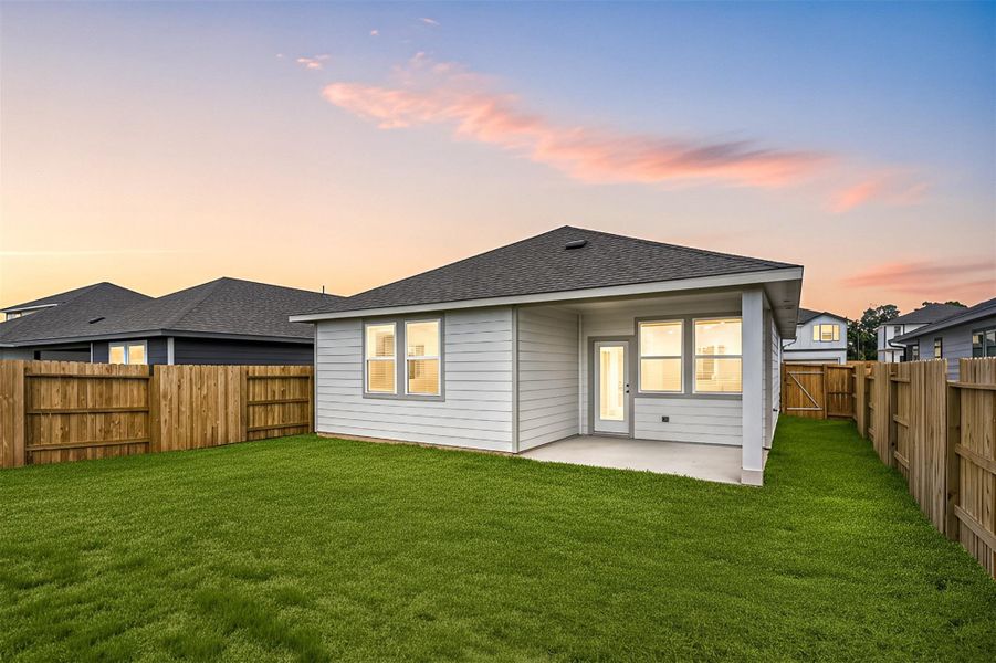 The fenced backyard offers plenty of space for outdoor fun and relaxation, complete with a covered patio for shade and comfort.