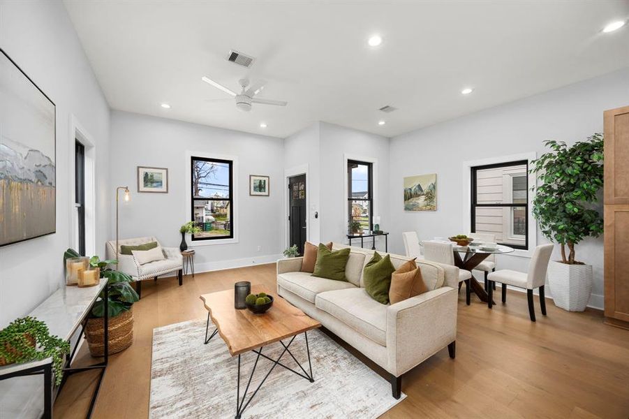 Bright and airy open-concept living and dining area featuring modern finishes, large windows, and a stylish neutral color palette perfect for entertaining.