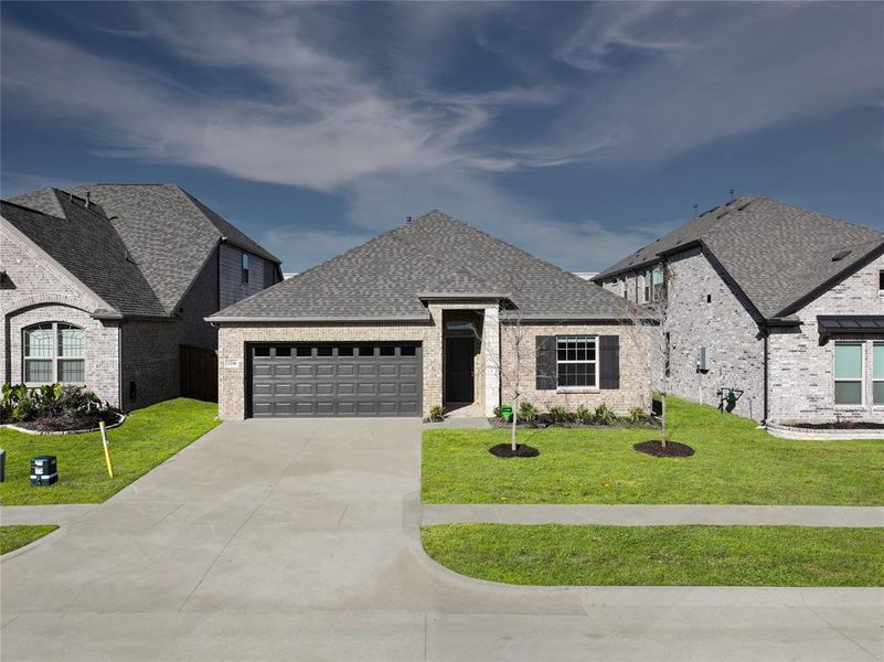 French country style house with a garage and a front lawn