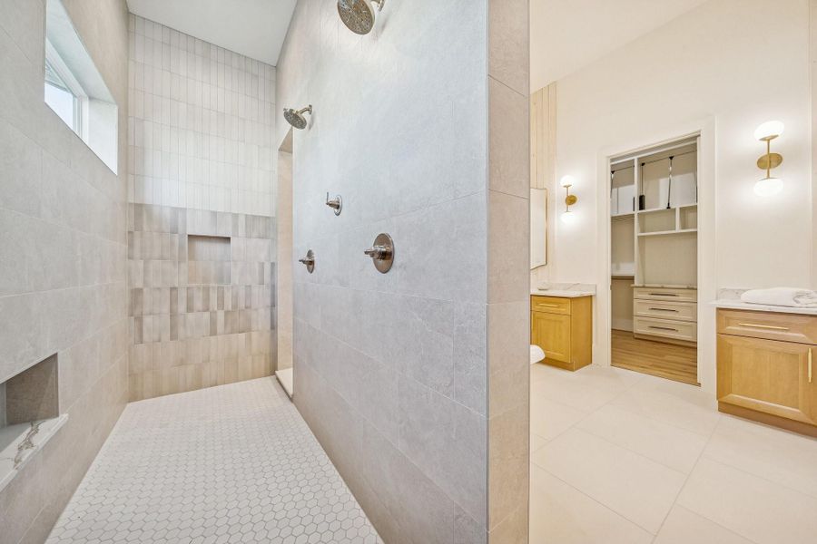 Double shower with built-in niches and subtle tile accents.