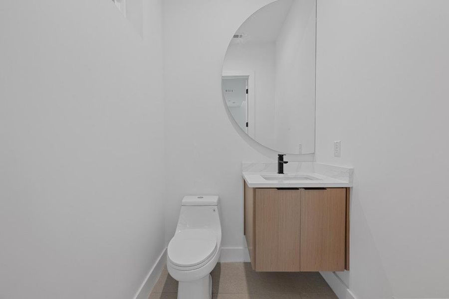 Half bath with vanity and light tile patterned floors