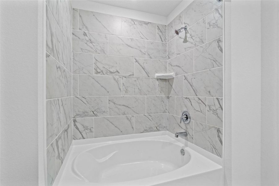 Pictured here is the large tub and shower combination with tile surround. Pictured here is the large tub and shower combination with tile surround.