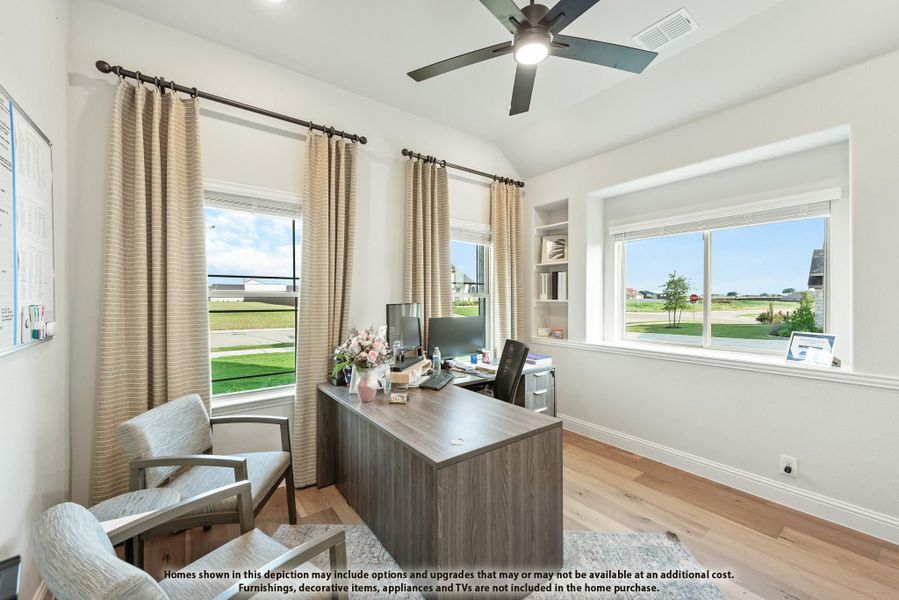 Home office with wood desk, built-in shelves, ceiling fan, and hardwood floors with large windows Home office with wood desk, built-in shelves, ceiling fan, and hardwood floors with large windows