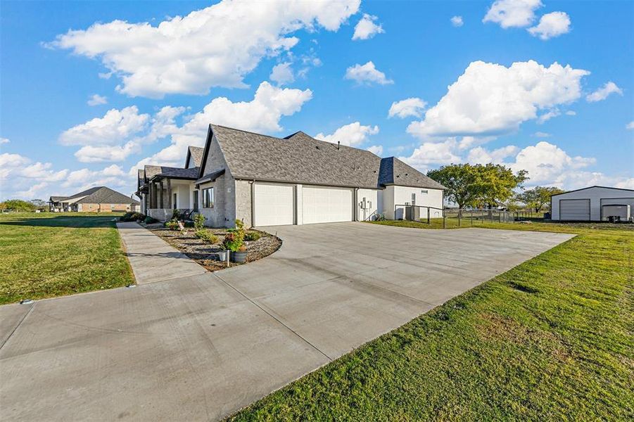 View of side of home with a garage and a lawn