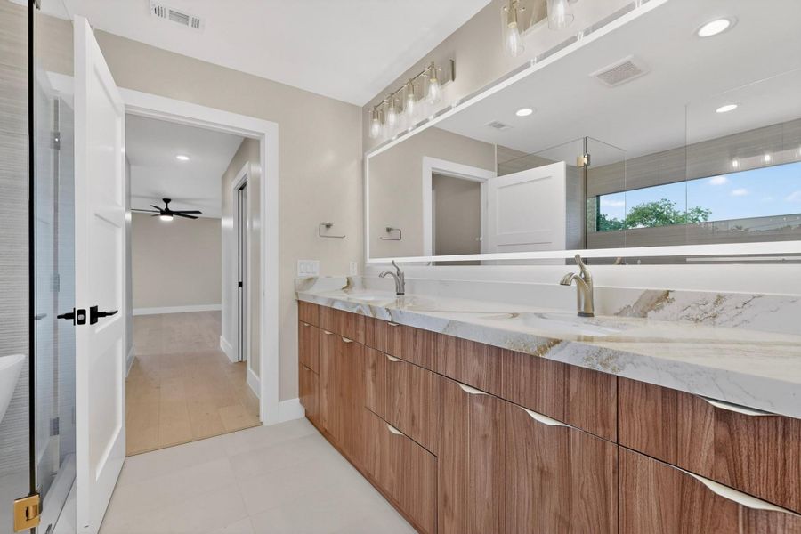 A well-appointed primary bathroom featuring a double vanity with ample storage and sleek fixtures.