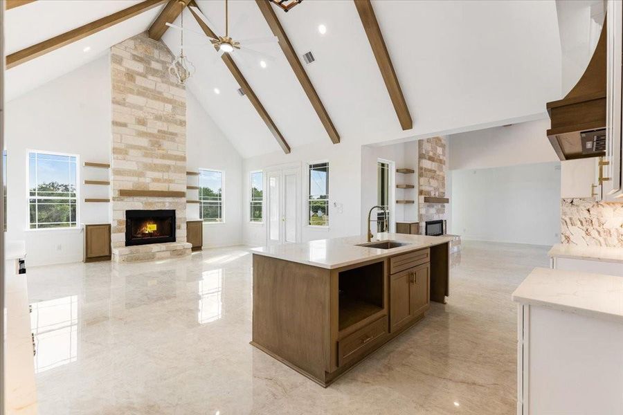 Alternative view of the kitchen showcasing vaulted ceilings with exposed beams and the spacious living area. Alternative view of the kitchen showcasing vaulted ceilings with exposed beams and the spacious living area.