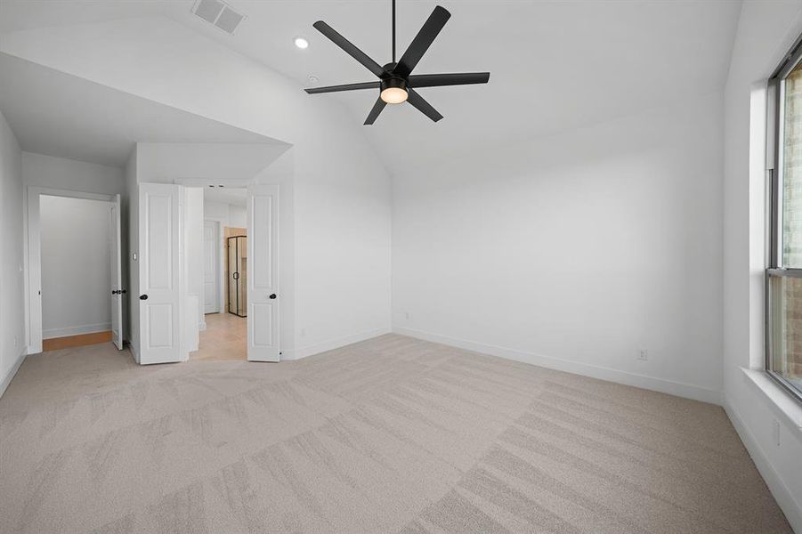 Unfurnished bedroom with light colored carpet, a ceiling fan, recessed lighting, and high vaulted ceiling