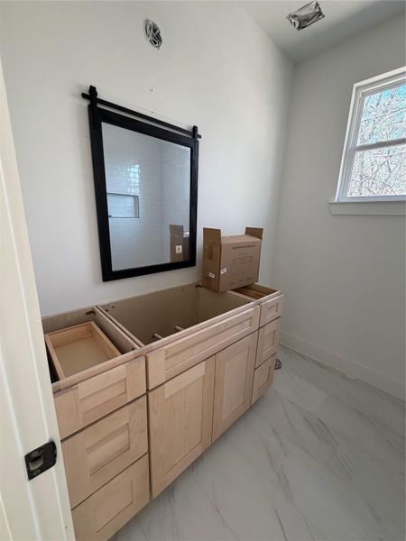 Bathroom featuring light marble finish flooring and baseboards