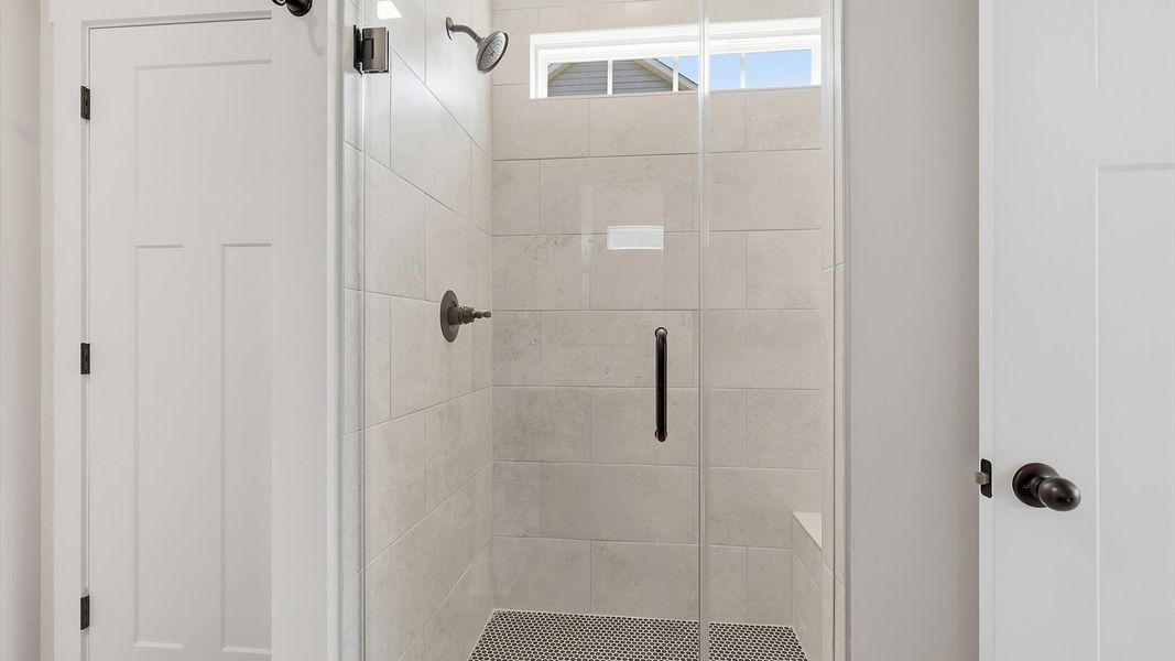 Tasteful primary bath with modern finishes and a thoughtfully designed walk-in shower at the Pinebrook community