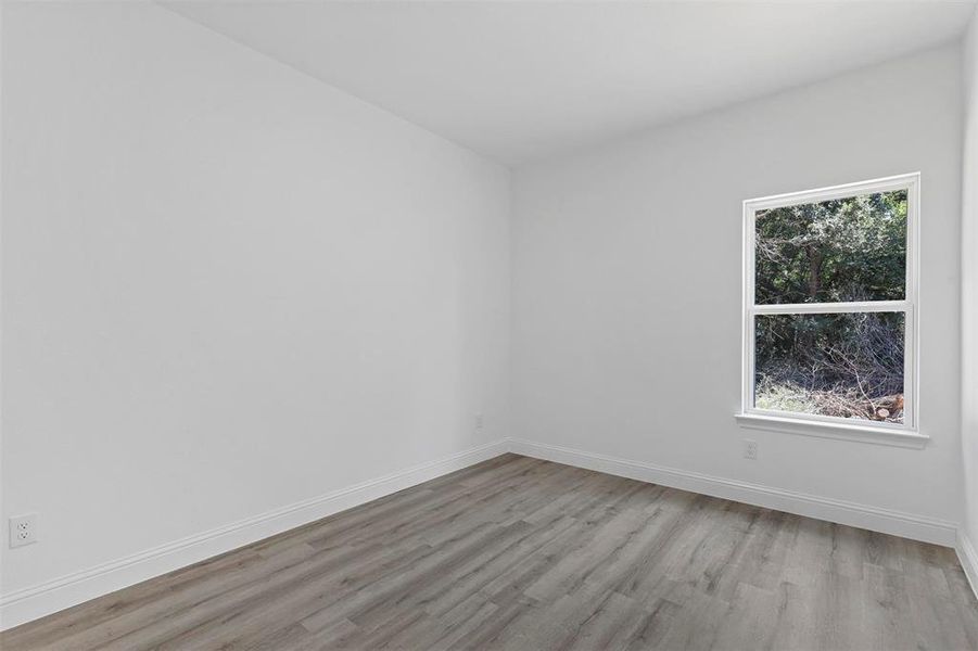 Empty room featuring a wealth of natural light and wood-type flooring