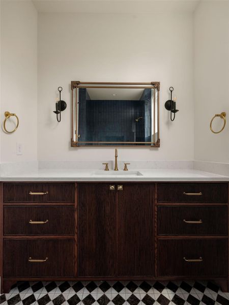 A refined bathroom vanity featuring a rich wood finish and classic checkerboard flooring.