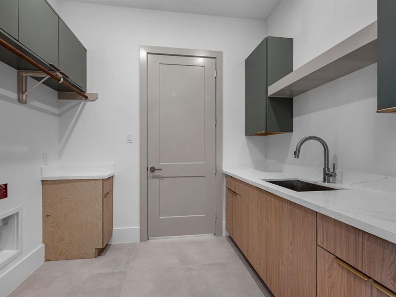 Designed with convenience in mind, the laundry space offers ample storage and functionality without compromising style.