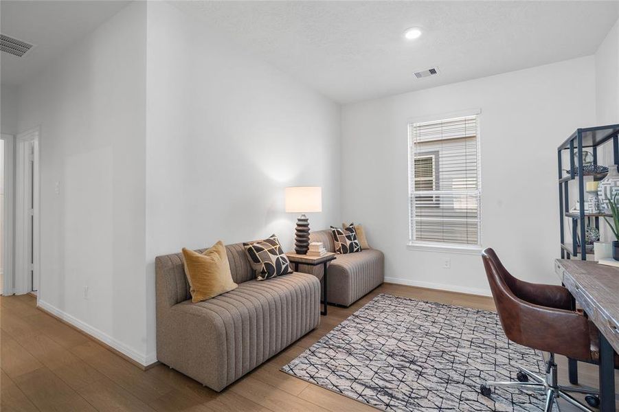 This den is the perfect spot for a home office! Featuring vinyl plank flooring, high ceilings, and a large window with privacy blinds.