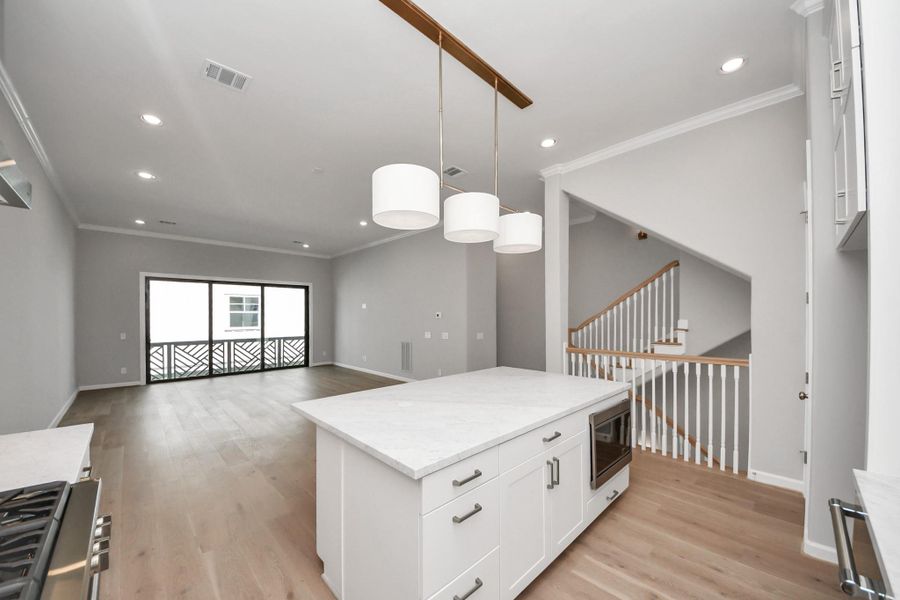 Large center island with seating, designer pendant lighting, and additional storage. Large center island with seating, designer pendant lighting, and additional storage.