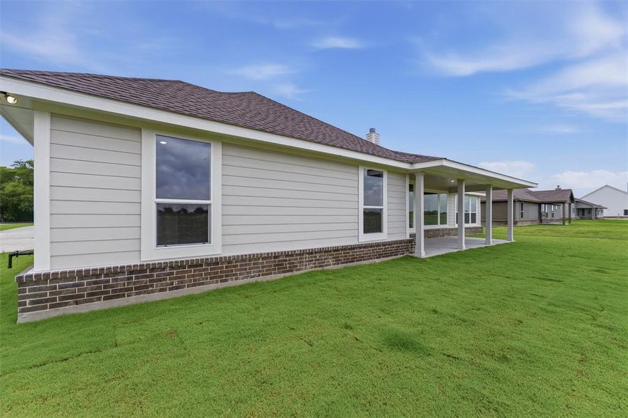 Exterior featuring light-colored horizontal siding, a dark shingle roof, and a dark brick foundation Exterior featuring light-colored horizontal siding, a dark shingle roof, and a dark brick foundation