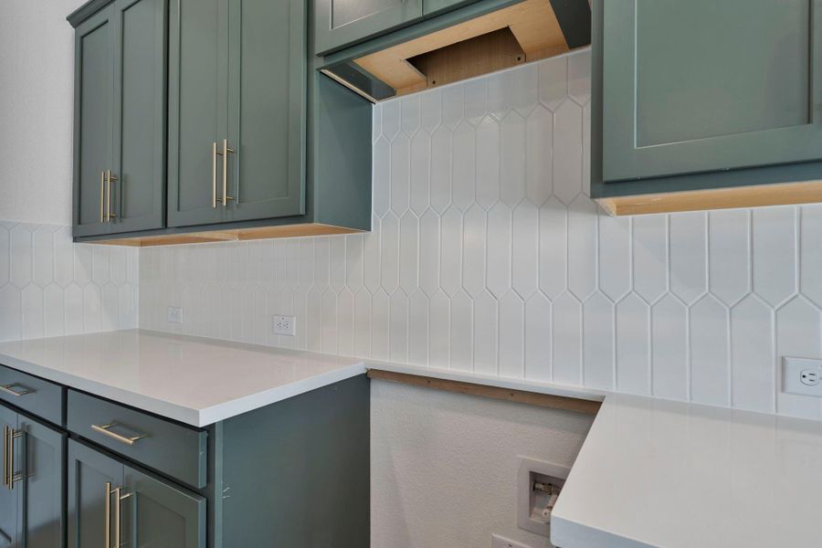 A close up of the unique picket backsplash that adds personality style to this unique kitchen.