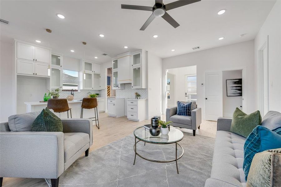 Living room with ceiling fan and light hardwood / wood-style floors