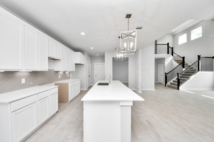 The open concept effortlessly connects the kitchen to the expansive family room, forming a perfect hub for gatherings. This seamless flow creates an inviting space where cooking and socializing come together harmoniously. Sample photo of completed home with similar floor plan. Actual colors and selections may vary.